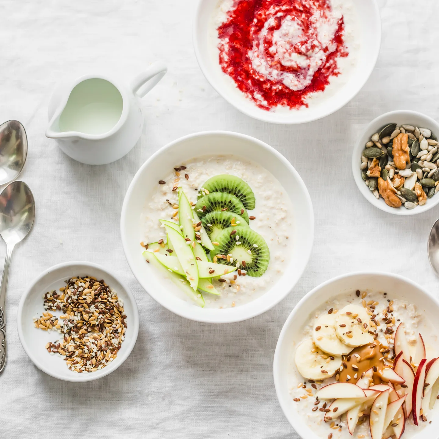 Bowls of yogurt, oats and soft fruit on a white table