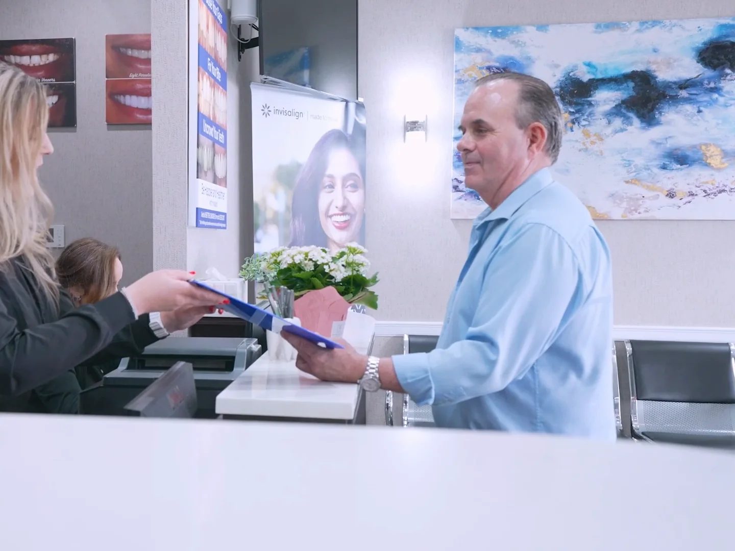 A patient handed his paperwork at the front desk