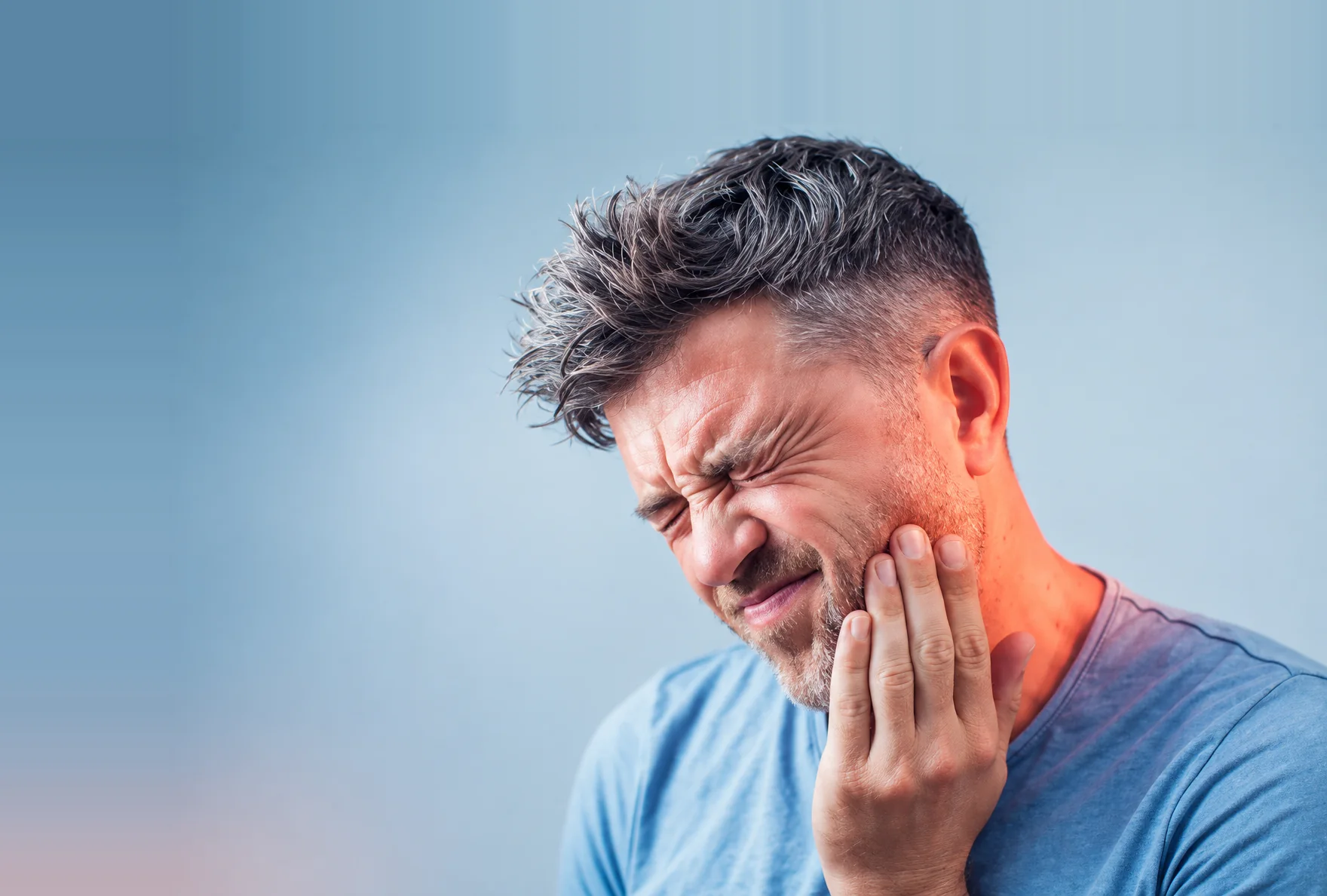 A man holding his jaw in pain