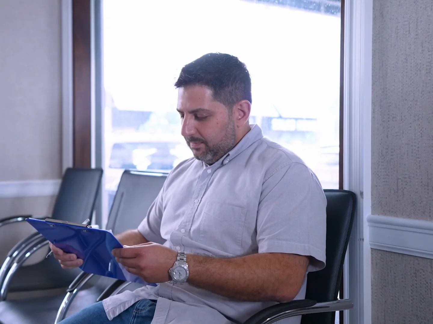 A new patient filling in his forms in the waiting room