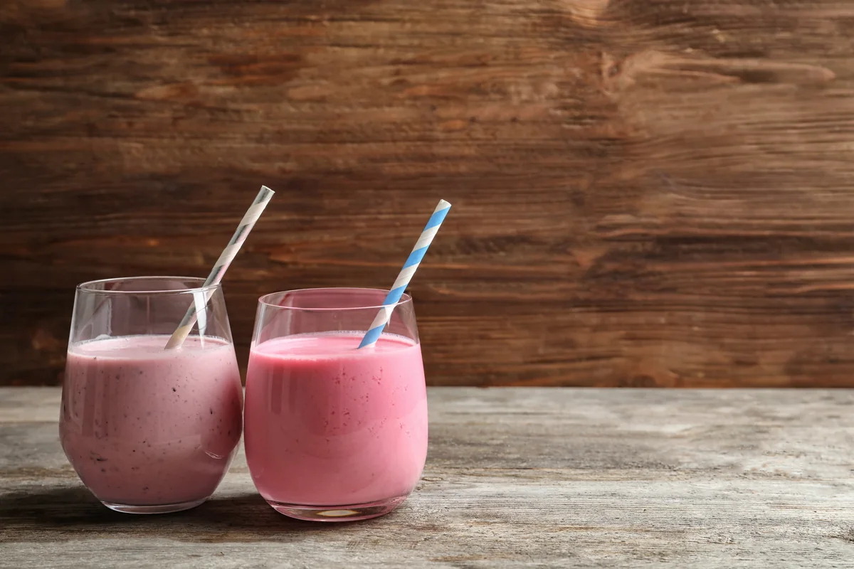 Two glasses of berry smoothie on a wooden table