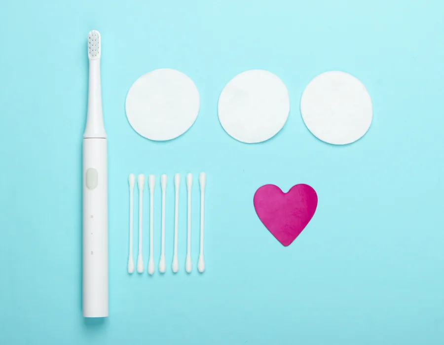 An electric toothbrush, cotton pads and swabs