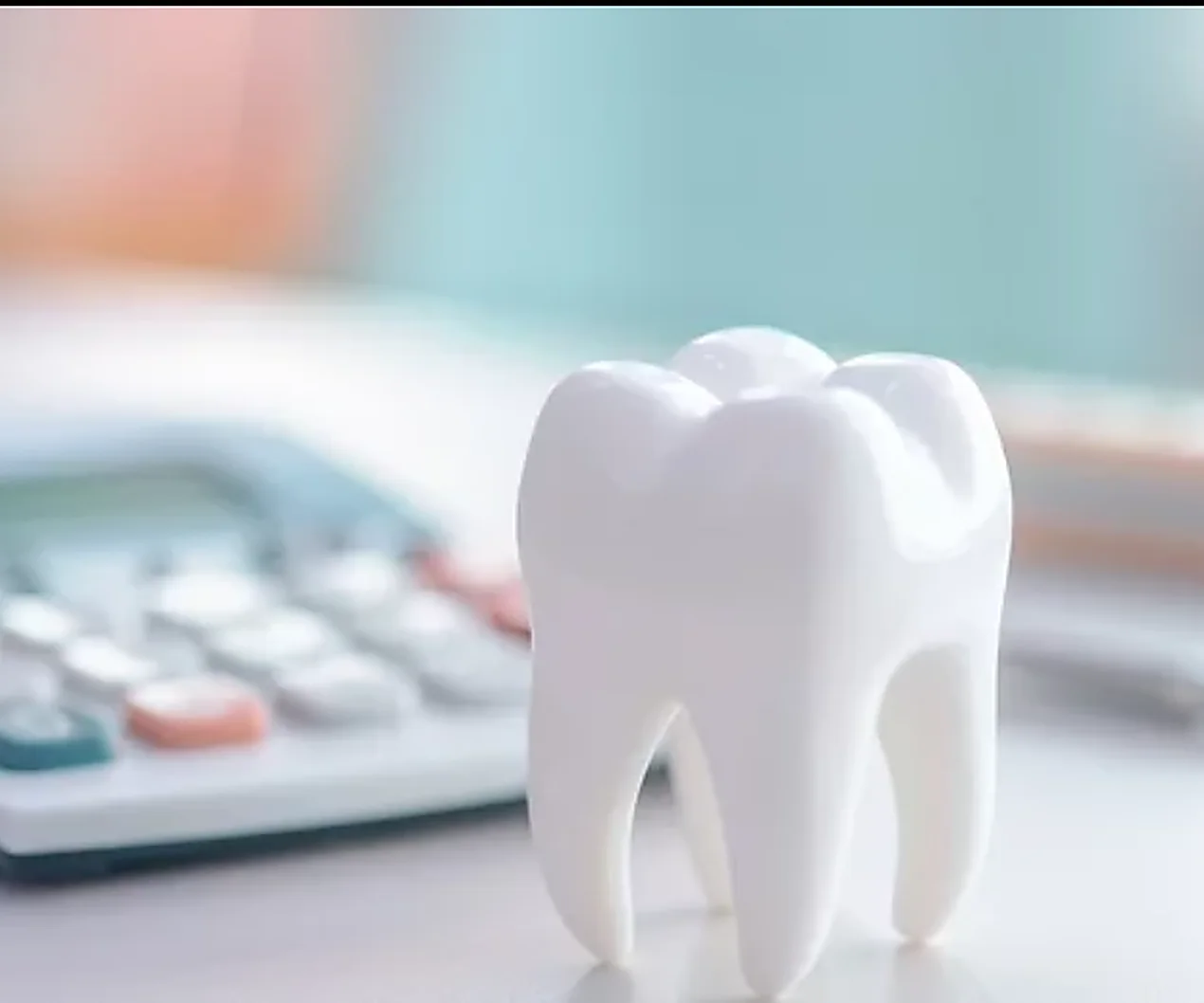 A model tooth beside a calculator